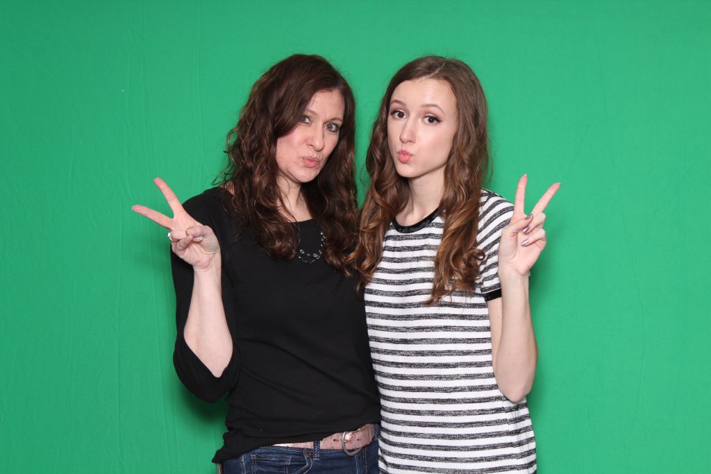 Photo booth guests in front of chroma key green backdrop